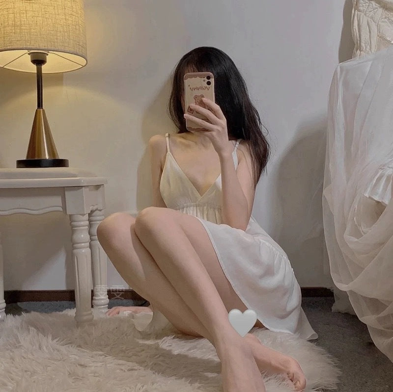 Woman taking a mirror selfie in a room with a lamp and bed.