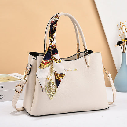 Beige handbag with decorative elements on a light background