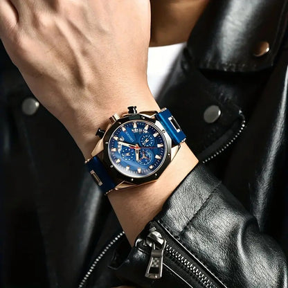 Close-up of a wrist wearing a blue watch with a detailed face, against a dark leather jacket background.