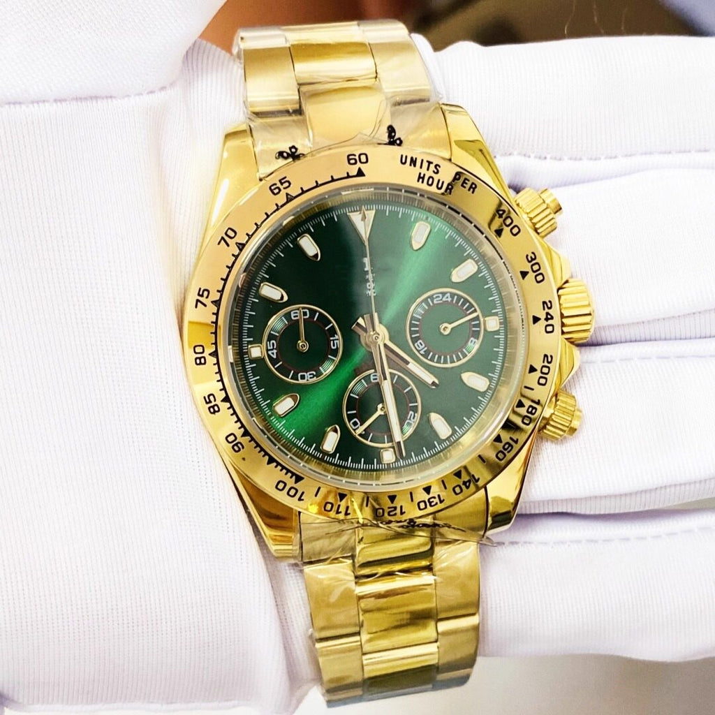 Gold wristwatch with a green face on a white background