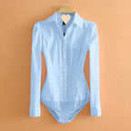 Light blue bodysuit with long sleeves on a hanger against an orange background