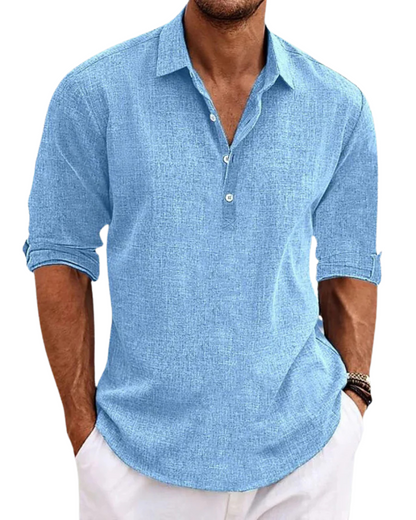 Man wearing a light blue button-up shirt with rolled-up sleeves on a white background