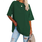 Person wearing a green oversized t-shirt and ripped jeans on a white background