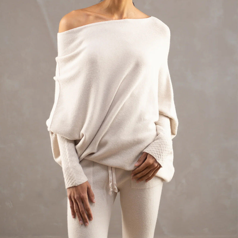 Person wearing a loose-fitting off-shoulder top and pants against a neutral background