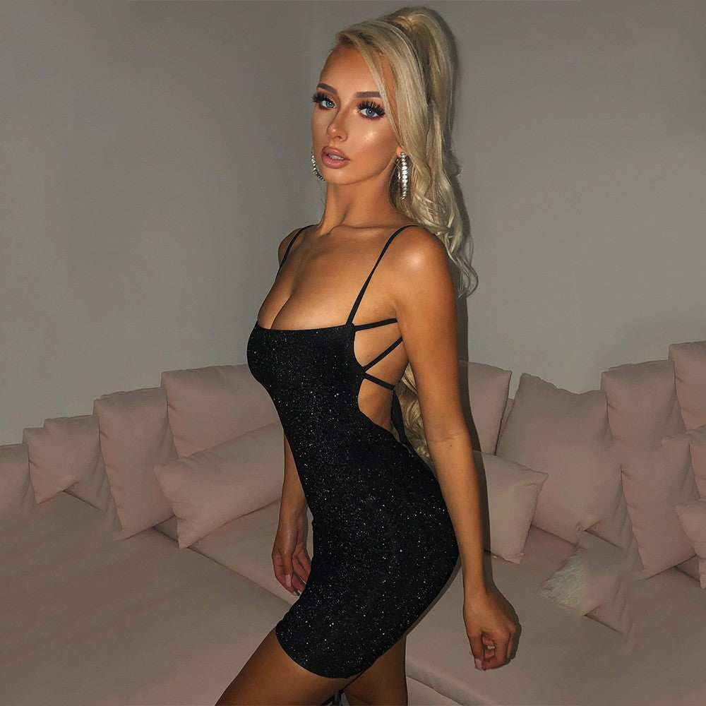 Woman in a black dress standing in a room with a neutral color scheme.