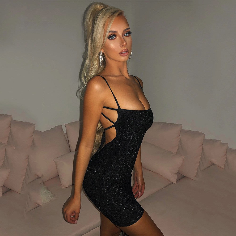 Woman in a black dress standing in a room with pink couches.