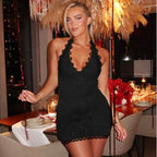 Woman in a black dress standing in a stylish indoor setting with decor elements.