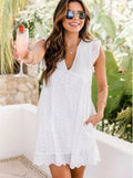 Woman in a white dress holding a drink outdoors