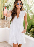 Woman in a white dress holding a drink outdoors