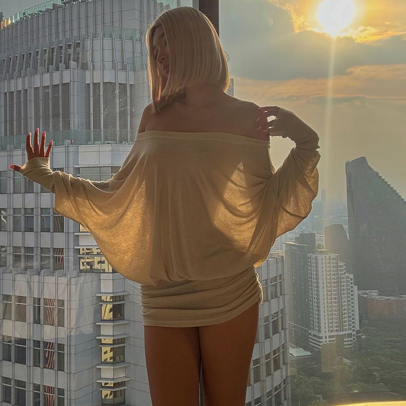 Woman standing on a balcony with a cityscape view during sunset.