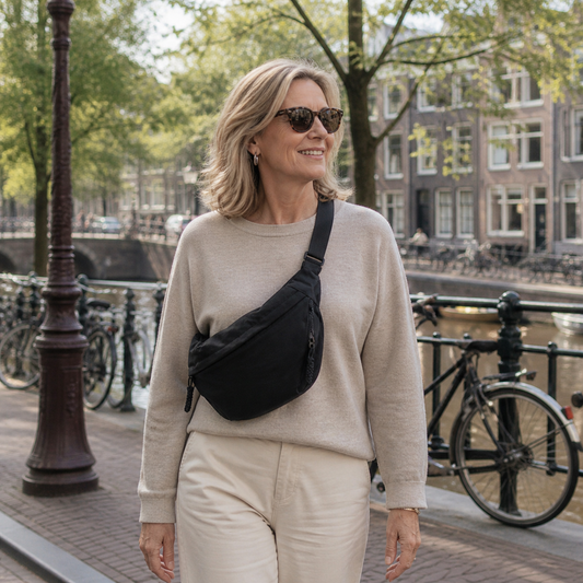 Woman walking along a canal with bicycles and buildings in the background