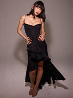 Woman wearing a black dress against a gray background