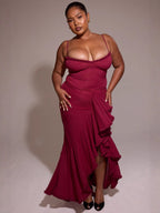 Woman wearing a burgundy evening gown against a plain background