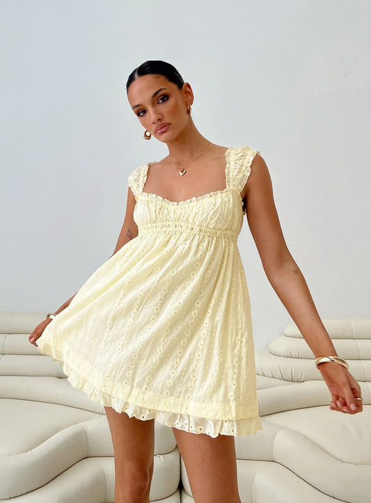 Woman wearing a light yellow dress against a white background
