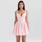Woman wearing a pink checkered dress against a white background