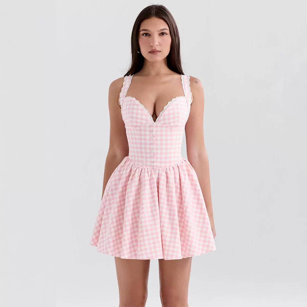 Woman wearing a pink checkered dress against a white background