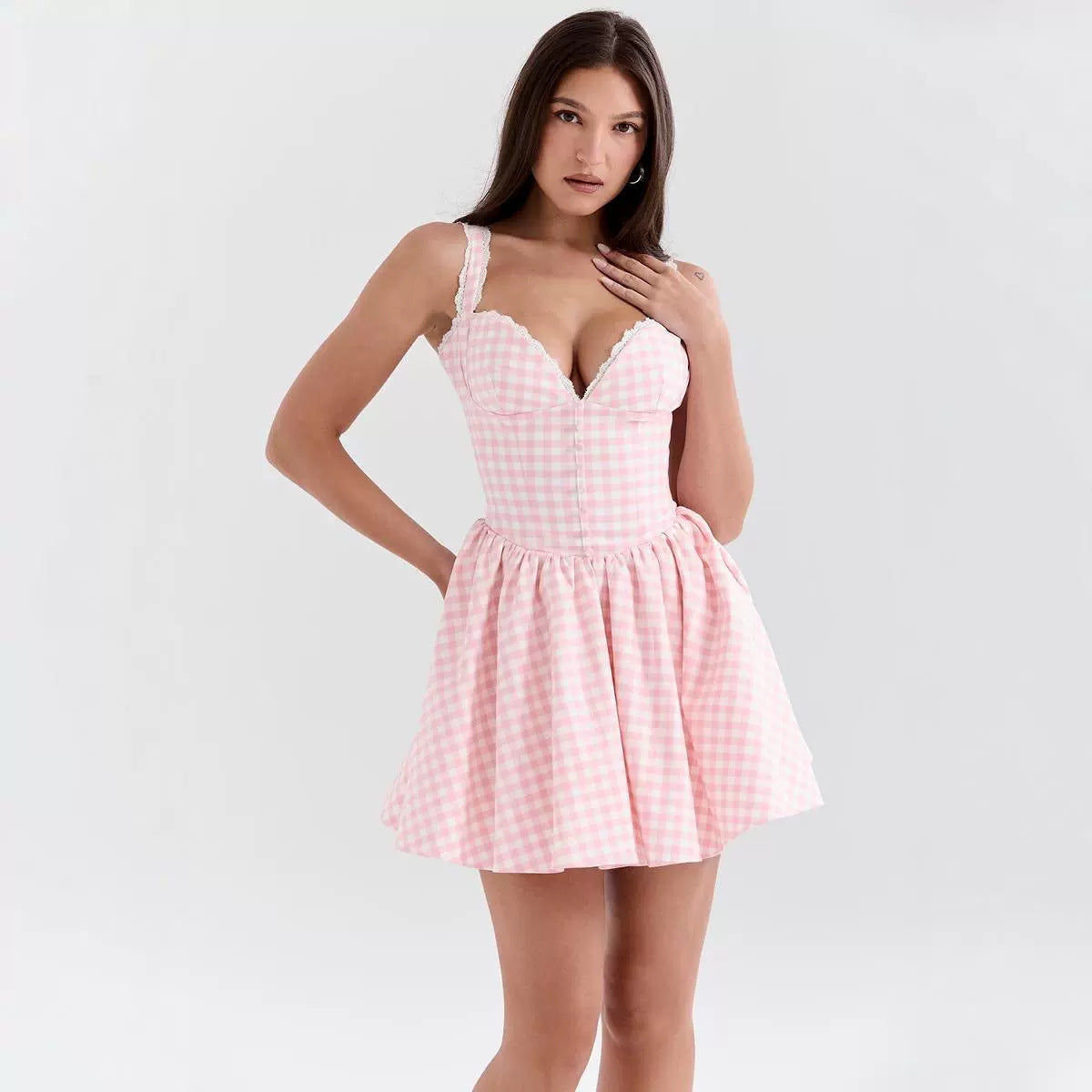Woman wearing a pink checkered dress on a white background