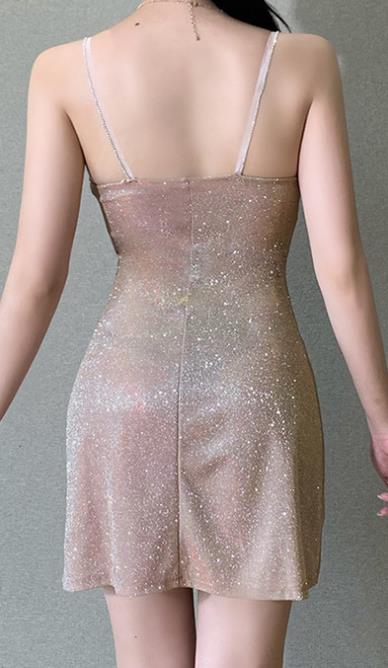 Woman wearing a sparkly, form-fitting dress on a gray background