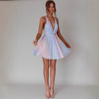 Woman wearing a sparkly, short dress against a plain background