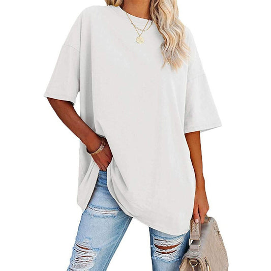Woman wearing a white oversized t-shirt and ripped jeans on a white background