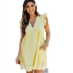 Woman wearing a yellow dress with ruffled sleeves on a white background