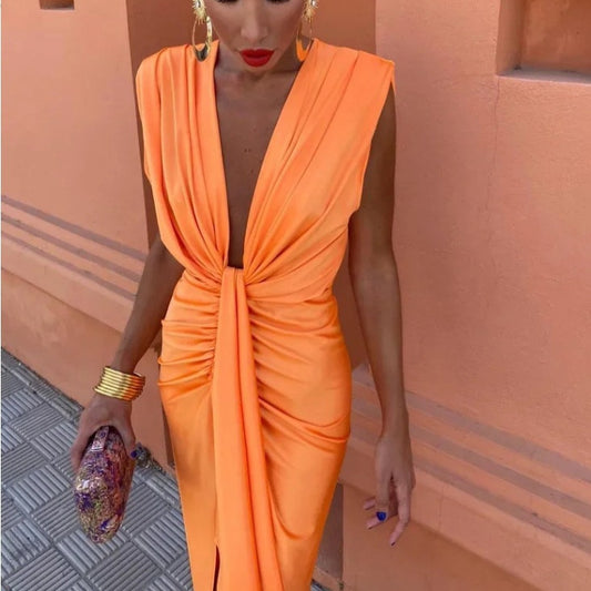 Woman wearing an orange dress with a textured wall background